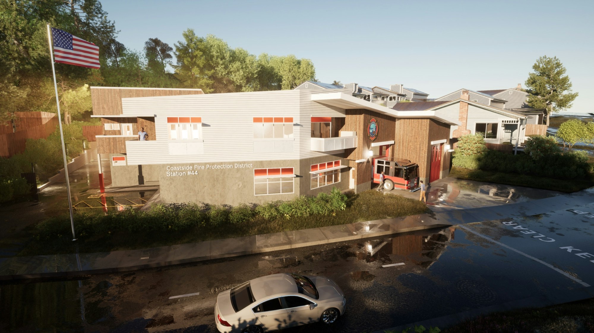 A fire station with a fire engine, American flag, and a person on the balcony.