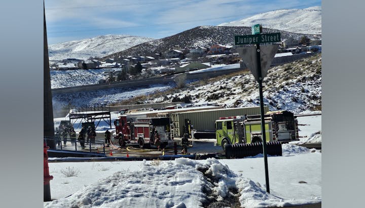 Emergency responders at a snowy scene with fire trucks and personnel, near Juniper Street, likely addressing an incident.