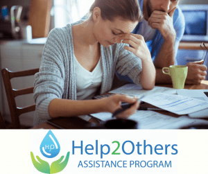 A woman appears stressed while reviewing documents, with a man in the background, alongside the Help2Others Assistance Program logo.
