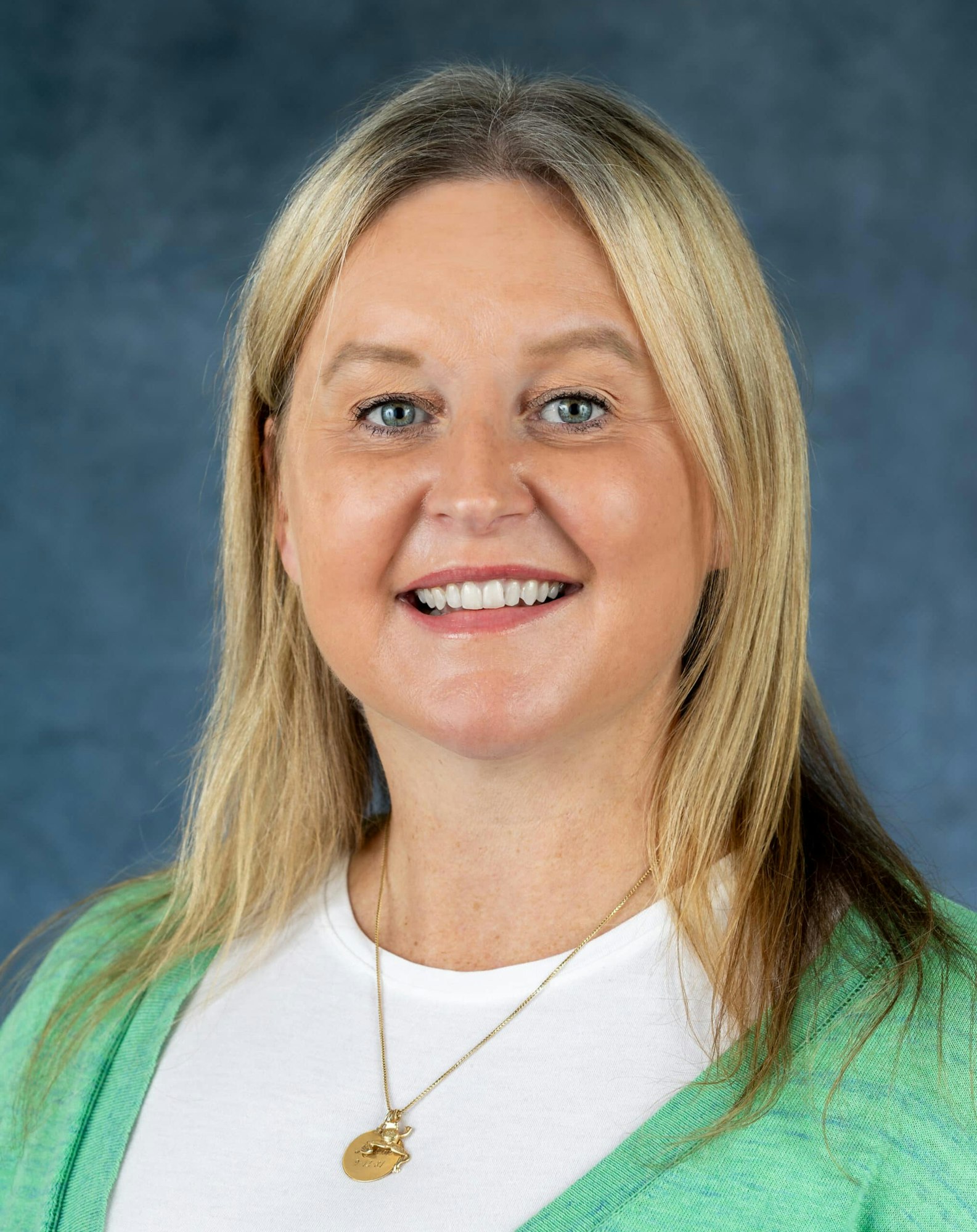 The image features a woman smiling, with blonde hair and a green cardigan, set against a blue background.