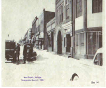 A vintage street scene in West Branch, Michigan, with old cars and buildings, circa 1941.