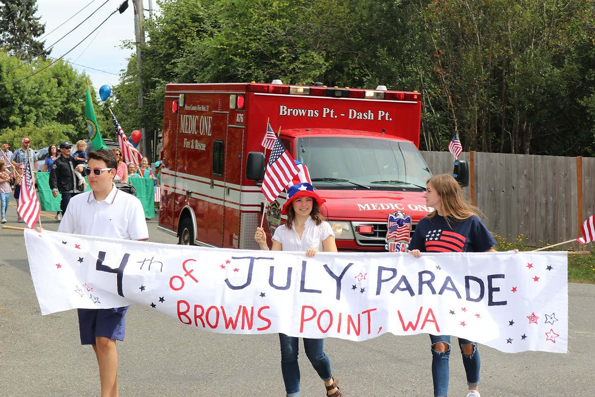 May contain: people, person, boy, male, teen, clothing, footwear, shoe, banner, text, hat, flag, accessories, glasses, jeans, pants, fire truck, transportation, truck, and vehicle