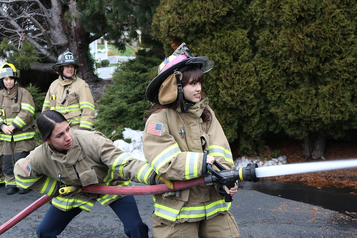 May contain: helmet, person, adult, female, woman, clothing, glove, footwear, shoe, and fireman