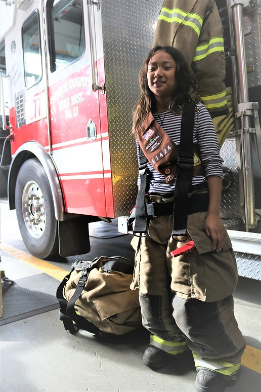 May contain: person, fireman, accessories, bag, handbag, fire truck, transportation, truck, and vehicle