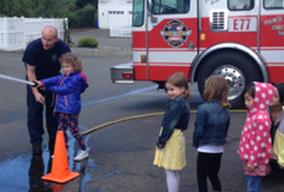 May contain: child, female, girl, person, fire truck, transportation, truck, vehicle, clothing, footwear, and shoe
