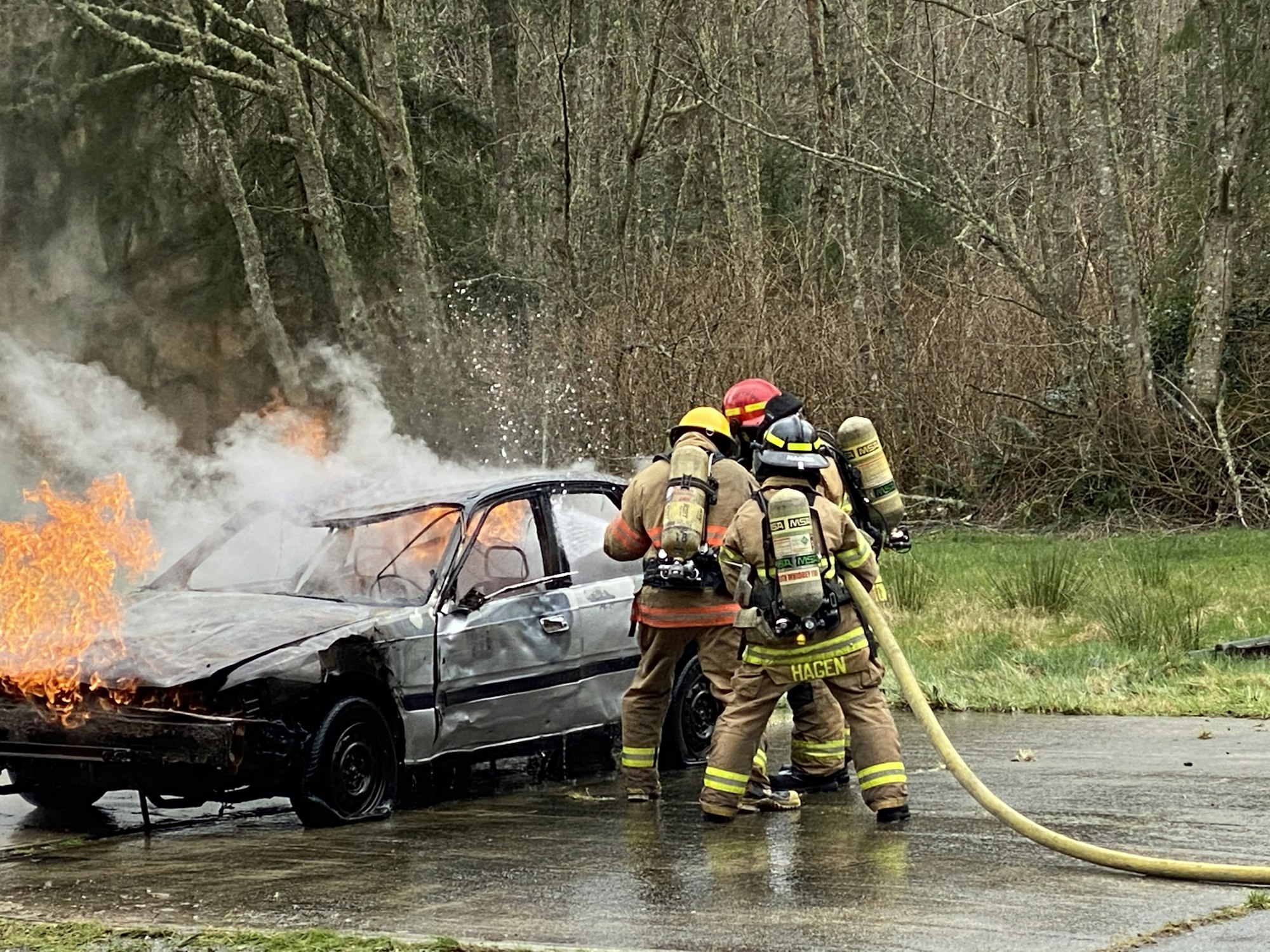May contain: person, fire, car, transportation, vehicle, helmet, and extinguishing fire