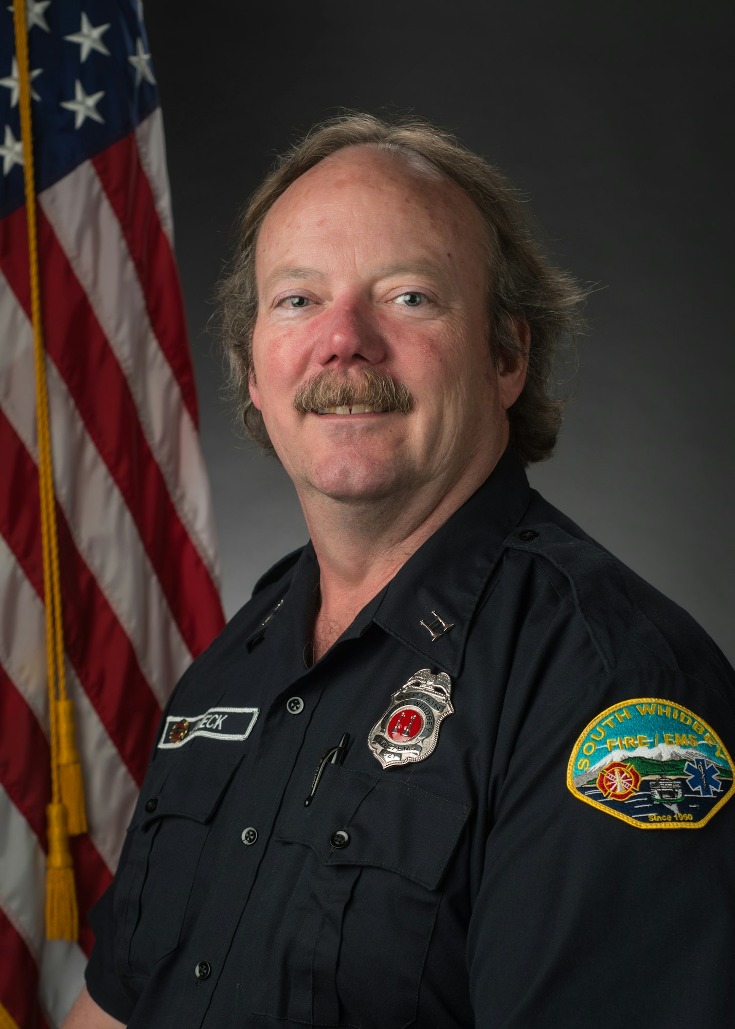 May contain: captain, officer, person, adult, male, man, police officer, flag, badge, logo, and symbol