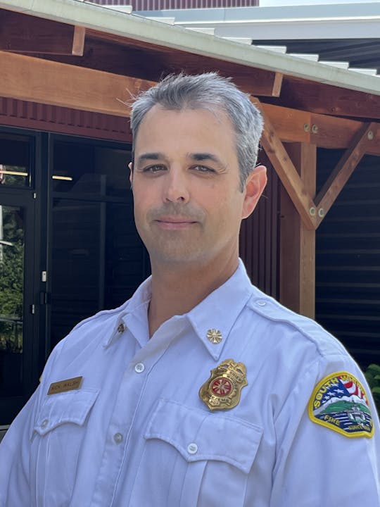 A person in a uniform with a badge, possibly a service member or first responder. (Image is rotated.)