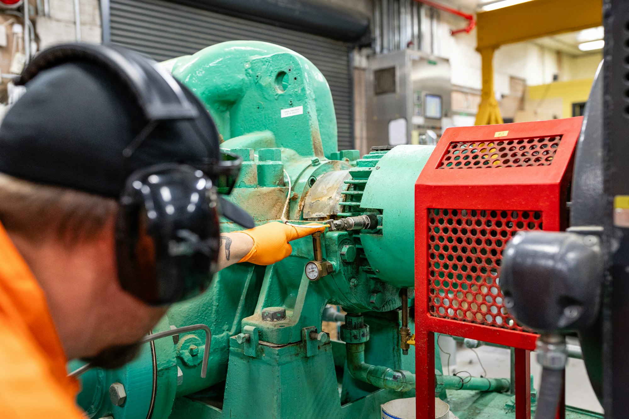 Pumps crew worker in safety gear looking at a pump oil level inside Luther Pass Pump Station.