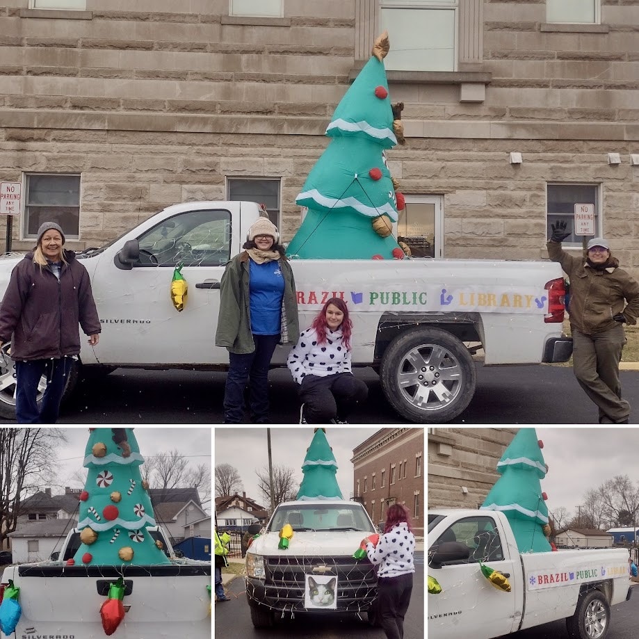 A decorated truck with a Christmas tree and "Brazil Public Library" sign, with four people posing.