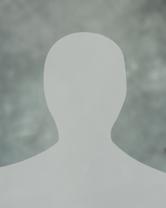 Silhouette of a person with no discernible features on a blurred background.