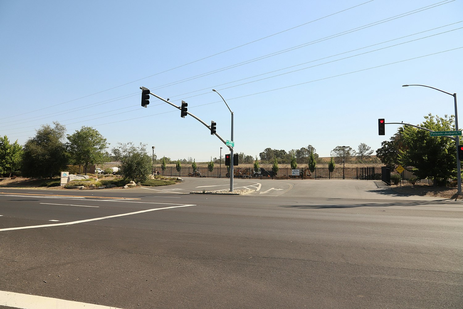 May contain: road, intersection, traffic light, light, street, urban, building, city, town, asphalt, and tarmac