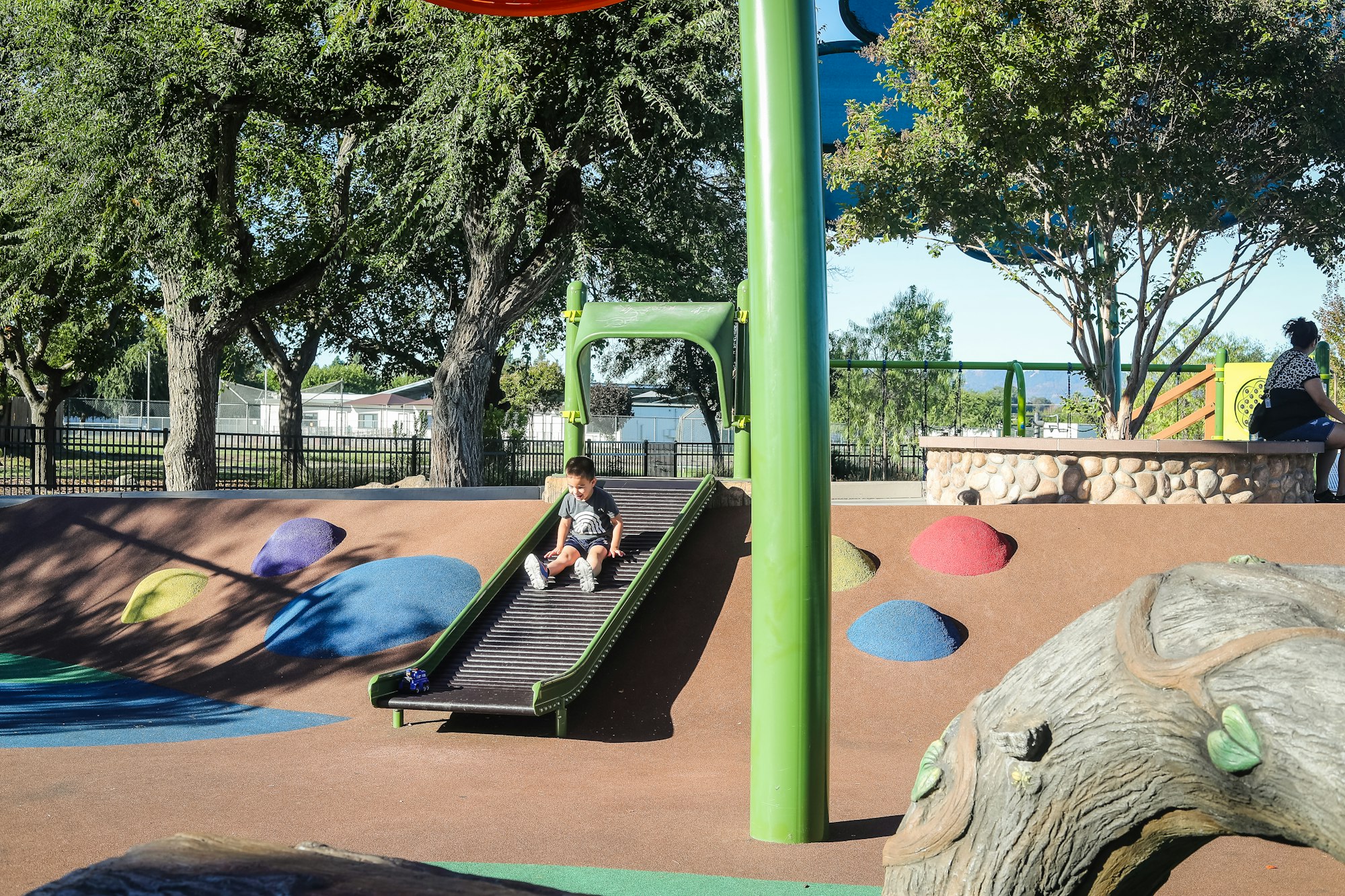 May contain: play area, outdoor play area, outdoors, clothing, footwear, shoe, person, accessories, bag, and handbag