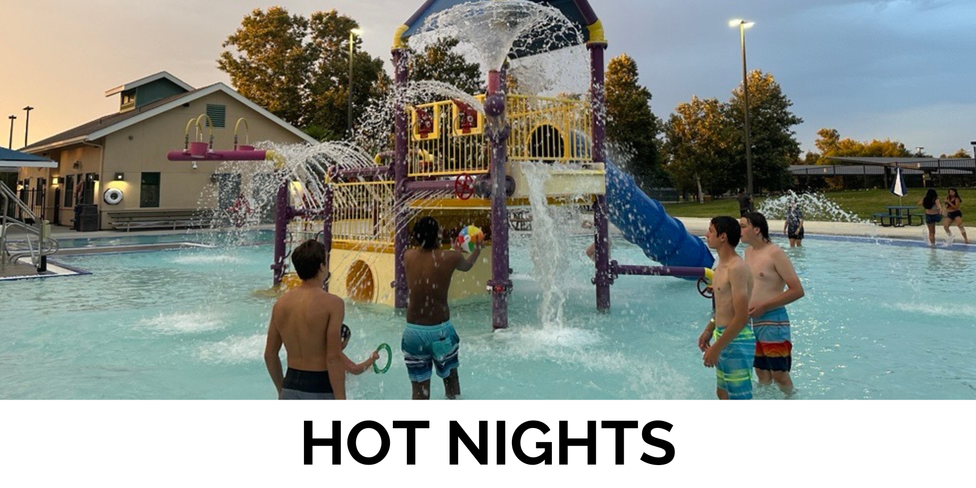 Kids playing in a pool with a water park structure, enjoying a warm evening filled with splashes and fun.