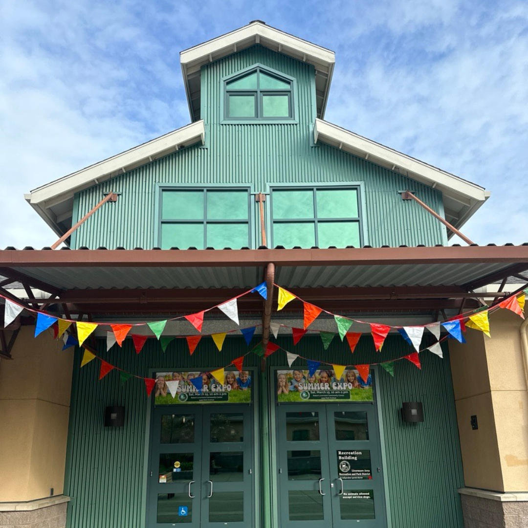 Green building with colorful pennant flags and "Summer Expo" banners over the entrance.