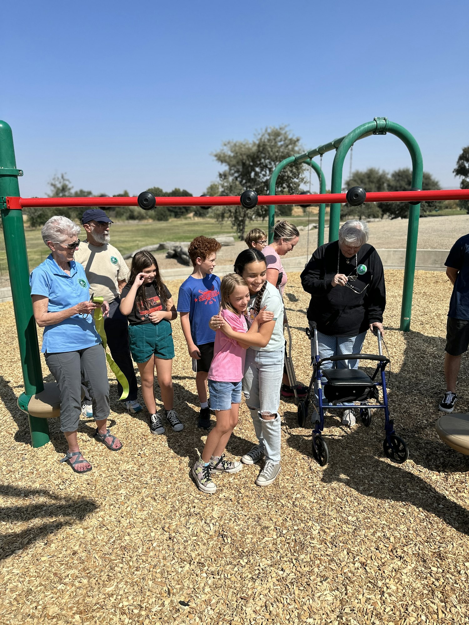 May contain: female, girl, person, teen, grass, nature, outdoors, park, plant, clothing, footwear, shoe, play area, outdoor play area, adult, male, man, and sandal