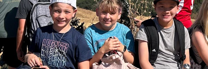 Group of smiling young people outdoors on a sunny day.