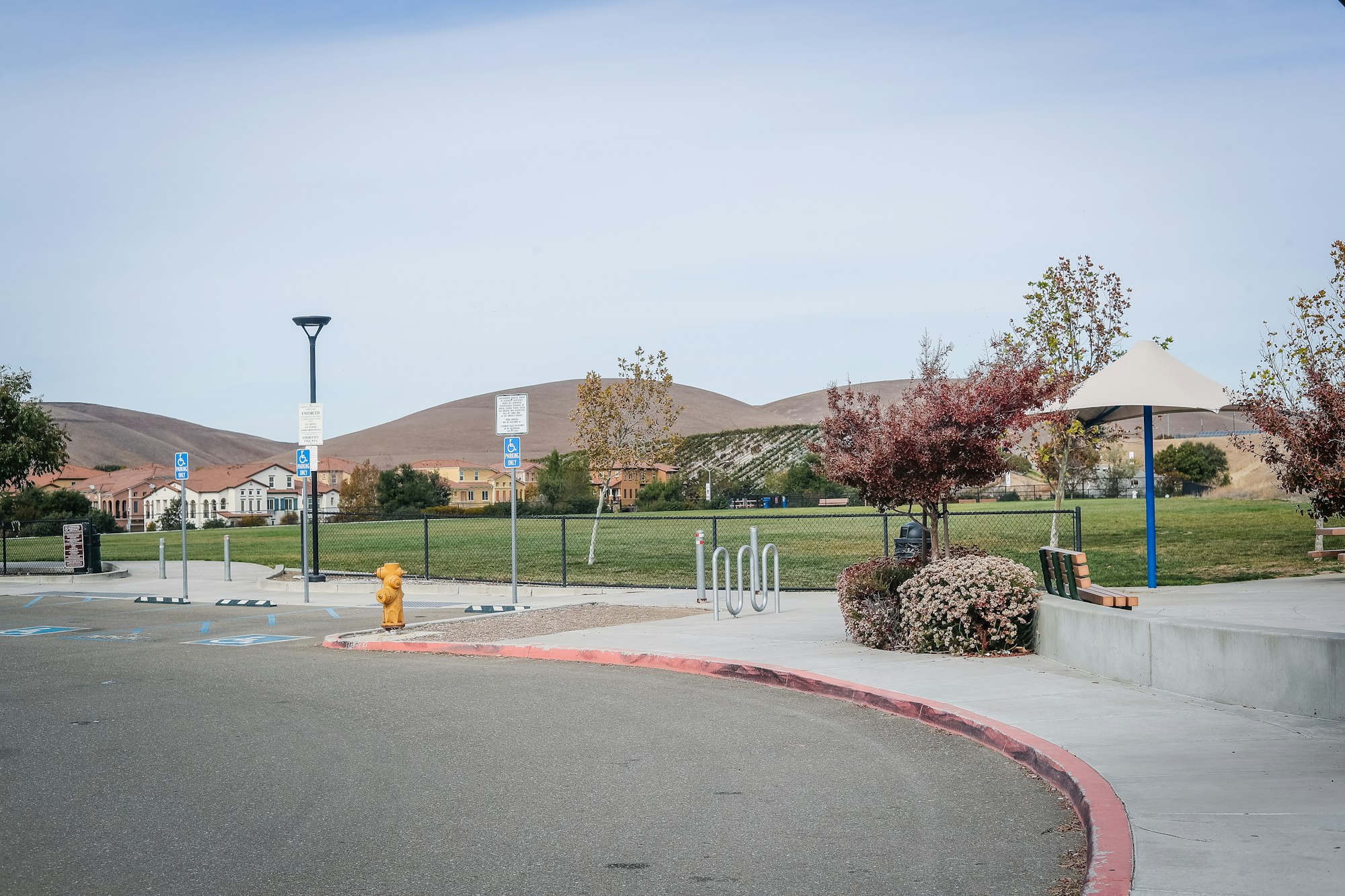 May contain: road, intersection, grass, plant, fire hydrant, hydrant, tarmac, path, sidewalk, bench, and furniture