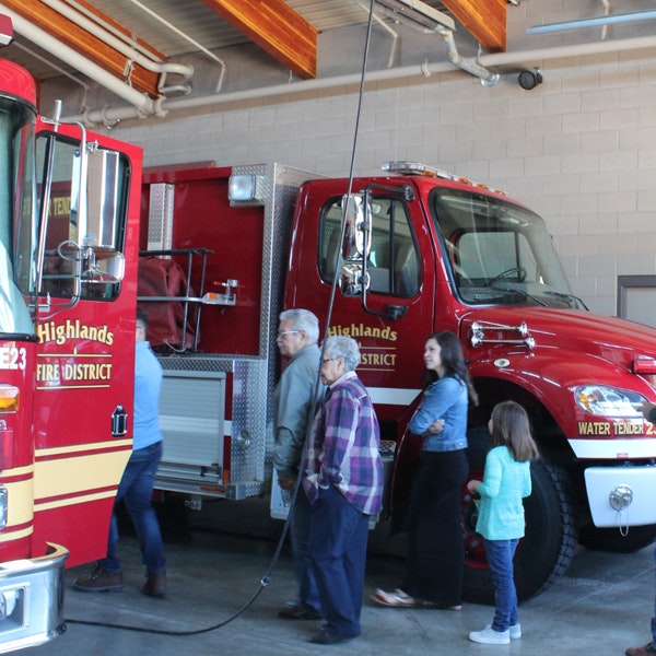 A firetruck and people inside a fire station.