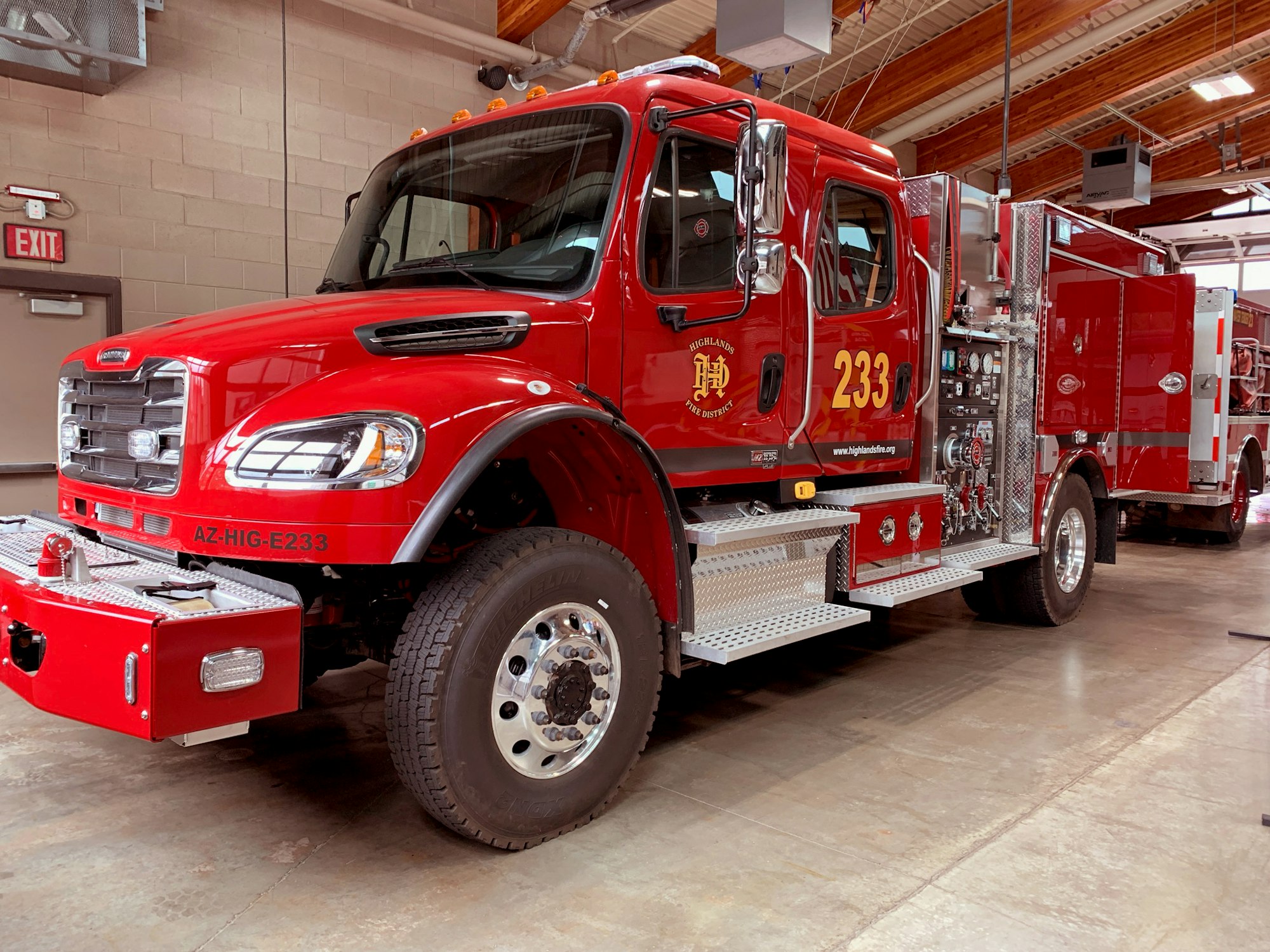 A red fire truck labeled "233" in a fire station.