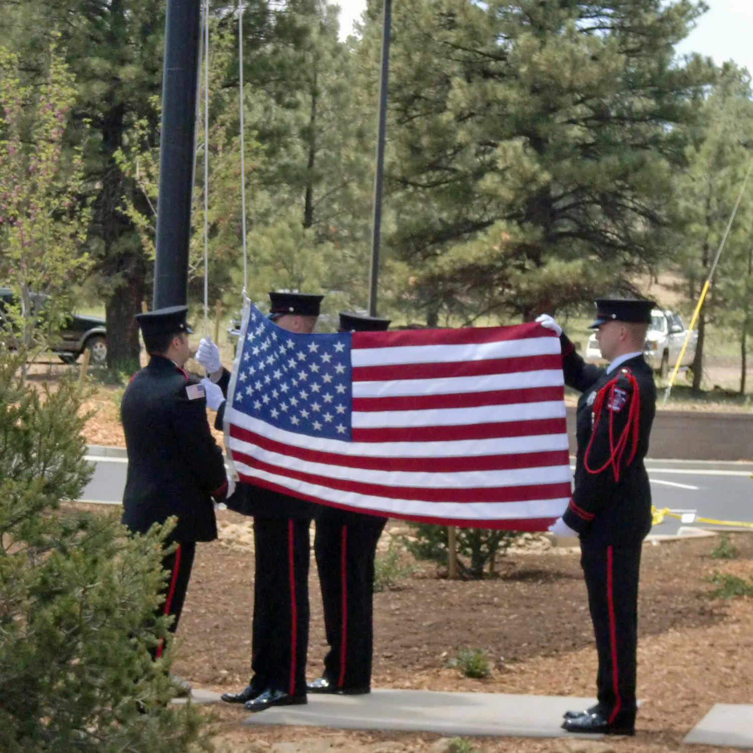 Uniformed personnel folding an American flag at a ceremony.