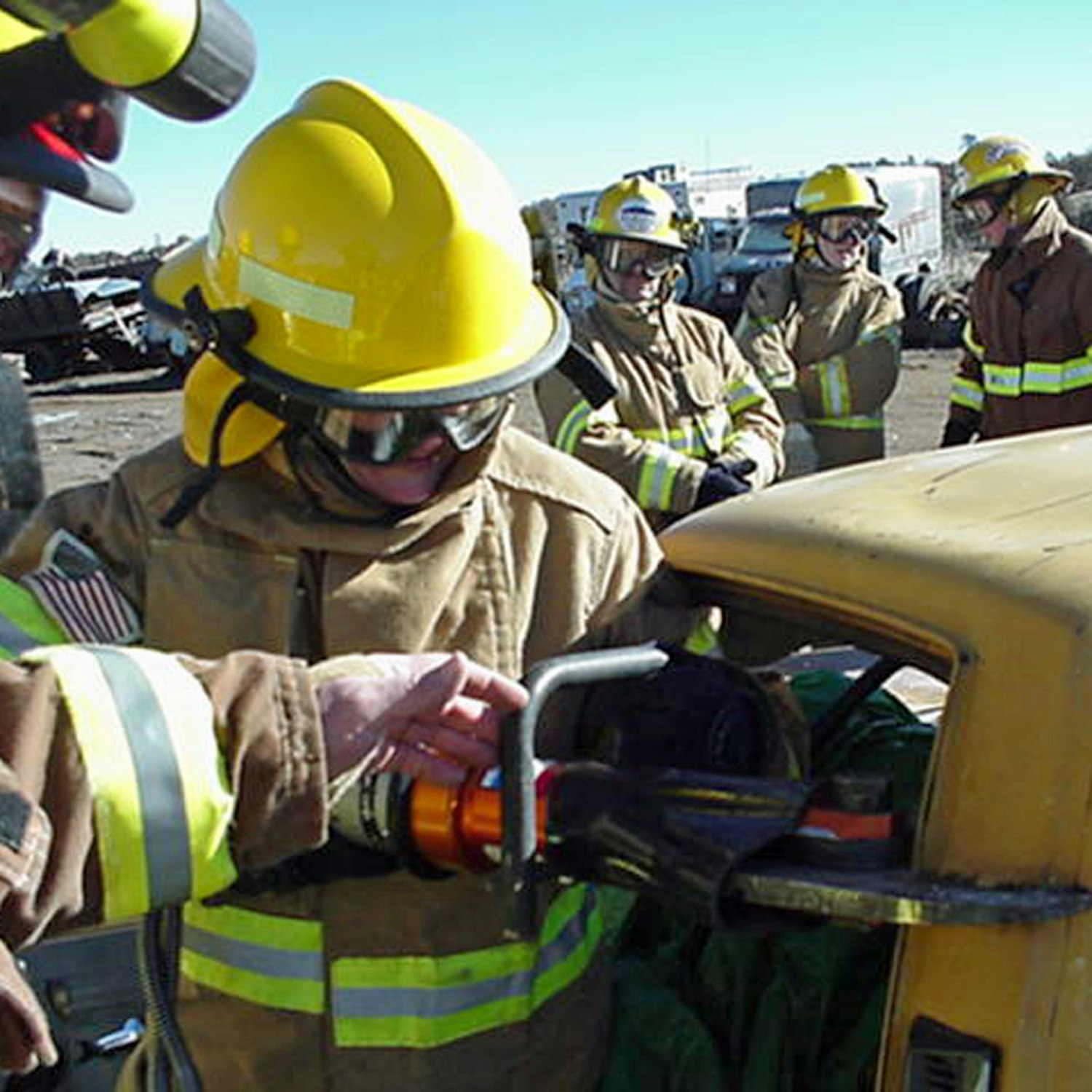Firefighters practice vehicle extrication using special equipment.