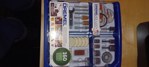 A Dremel rotary tool accessory set with 160 pieces, including sanding, cutting, and polishing attachments, in a plastic organizer box.