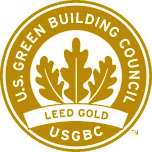 Circular gold logo of the U.S. Green Building Council, LEED Gold certification, with oak leaf design.