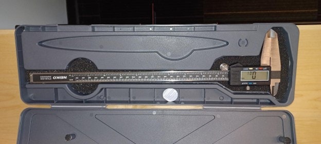 A digital caliper inside an open plastic case, displaying "0.0" on its screen.