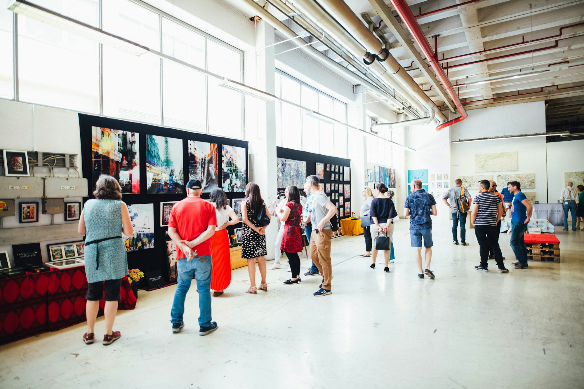 People viewing artwork in a bright, spacious gallery.