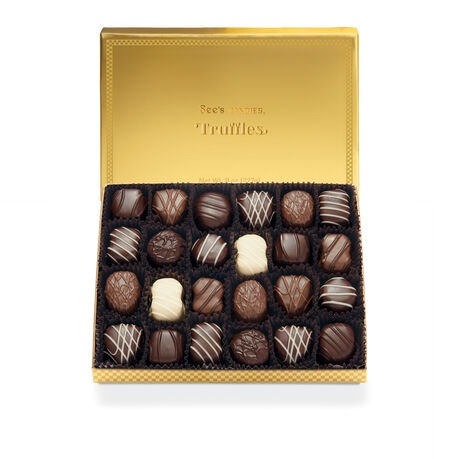 A gold box of assorted truffles with decorative designs, including dark, milk, and white chocolate varieties.