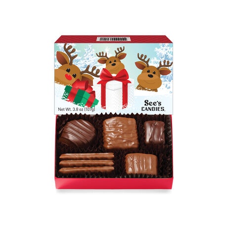 A box of See's Candies with assorted chocolates, featuring a reindeer-themed holiday design on the packaging.