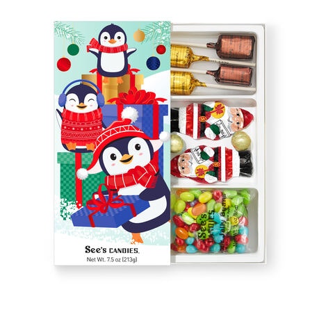 A festive See's Candies box featuring penguin designs filled with assorted chocolates and colorful candies, perfect for the holidays.