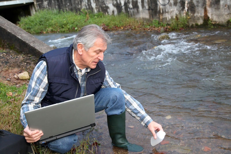 May contain: computer, electronics, laptop, pc, clothing, pants, face, head, person, photography, portrait, sitting, and water