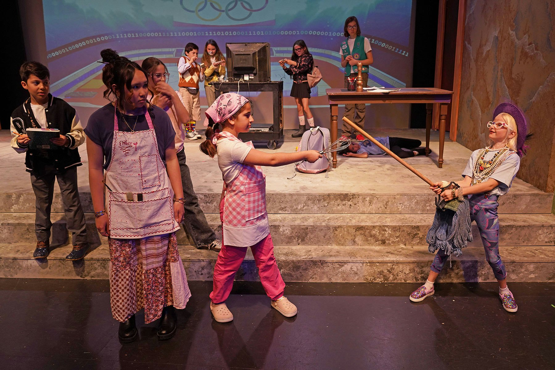 A vibrant stage scene with kids in costumes, engaging in a playful standoff, representing creativity and fun in a performance.