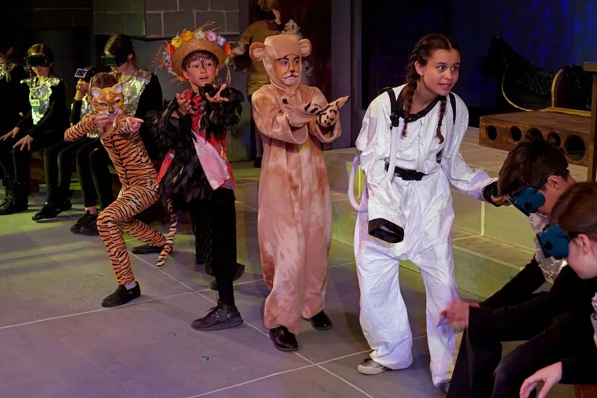 Children dressed in costumes, possibly for a play, featuring animals and a scientist.