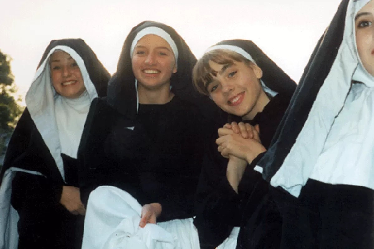 Four people in nun costumes smiling at the camera.