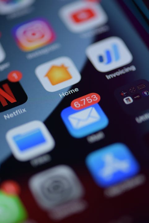 Close-up of a smartphone screen with app icons and a notification for 6,753 unread emails.