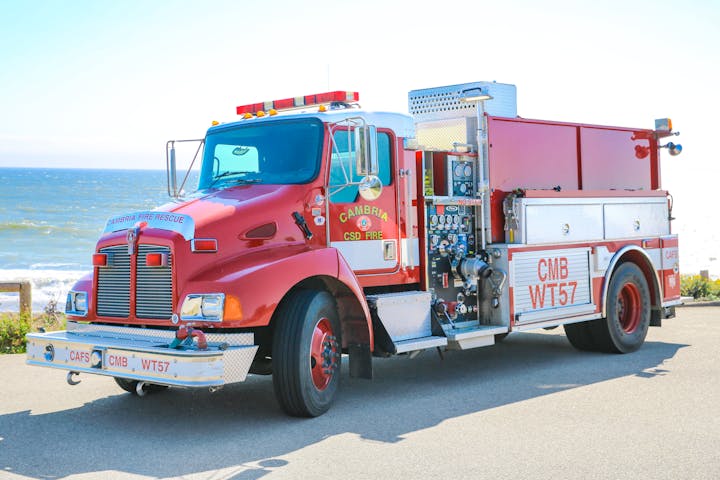 A red fire truck parked near a coastline.