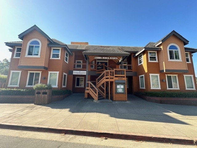 Two-story orange building with "Corner Medical Building" sign, clear sky, and a street in front.