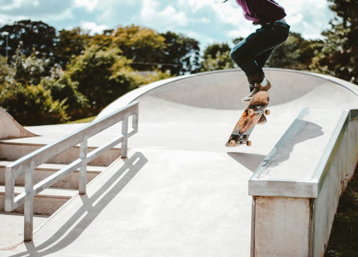 A skateboarder doing a trick at a skatepark.