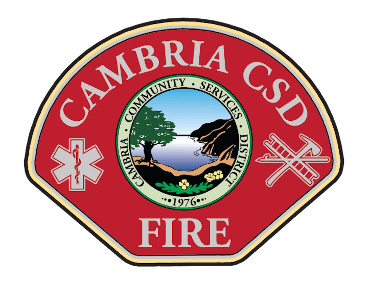 Cambria CSD Fire badge featuring a tree, cliff, and sunrise within a circle, with emergency and fire symbols on a red background.