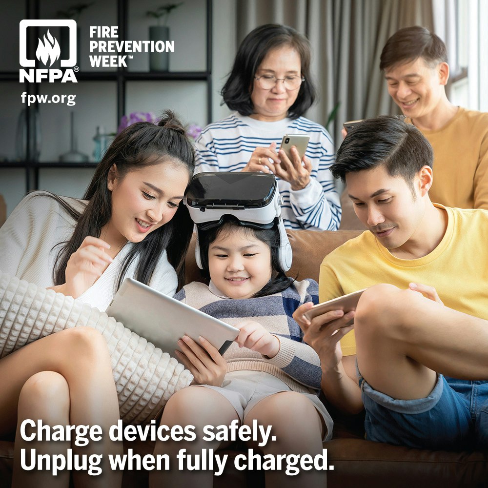 Family using devices promotes safe charging. Reminder: Unplug when fully charged. NFPA Fire Prevention Week.