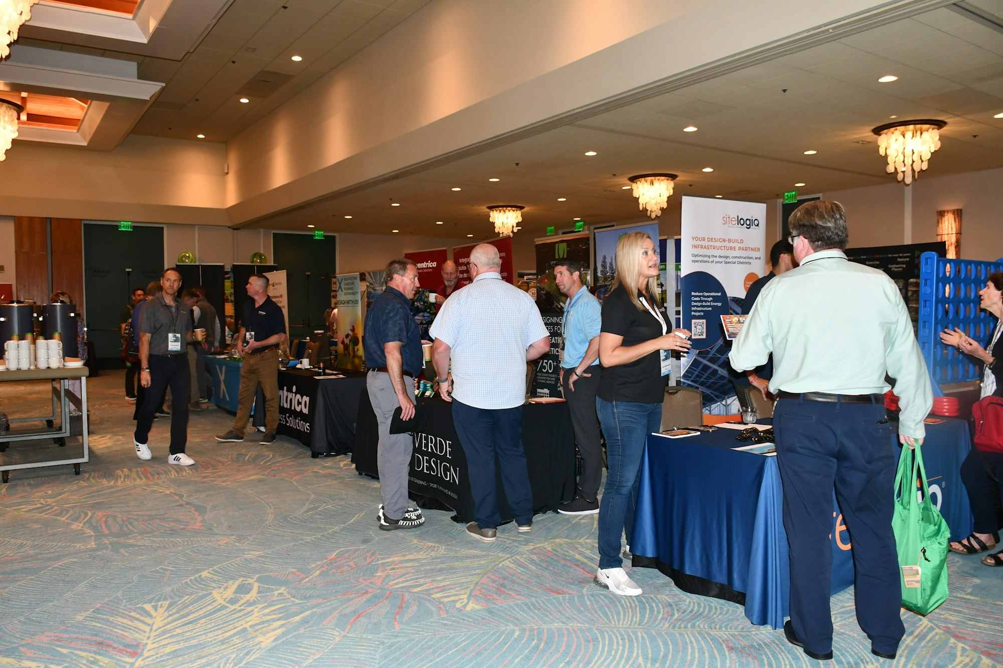 People networking at a business trade show with various booths and displays.