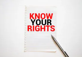 A notepad with the phrase "KNOW YOUR RIGHTS" in bold red and black text, accompanied by a pen.