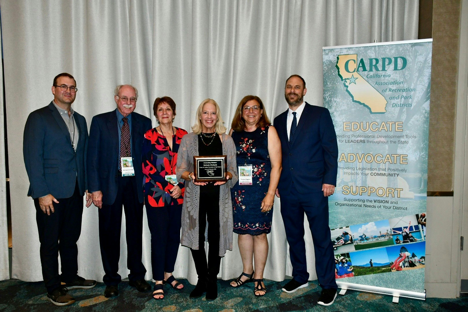 A group of people at an event posing with an award and a banner for the California Association of Recreation and Park Districts.