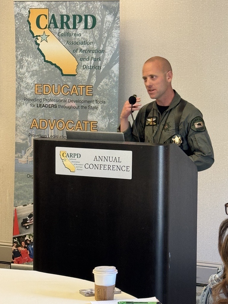 Person giving a presentation at the CARPD Annual Conference, standing at a podium with a microphone, wearing a uniform.