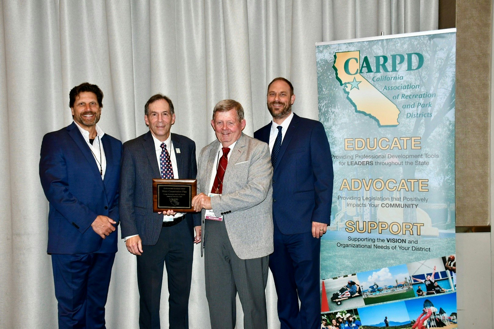 The image shows four men at an event, one presenting an award, alongside a banner for the California Association of Recreation and Park Districts.