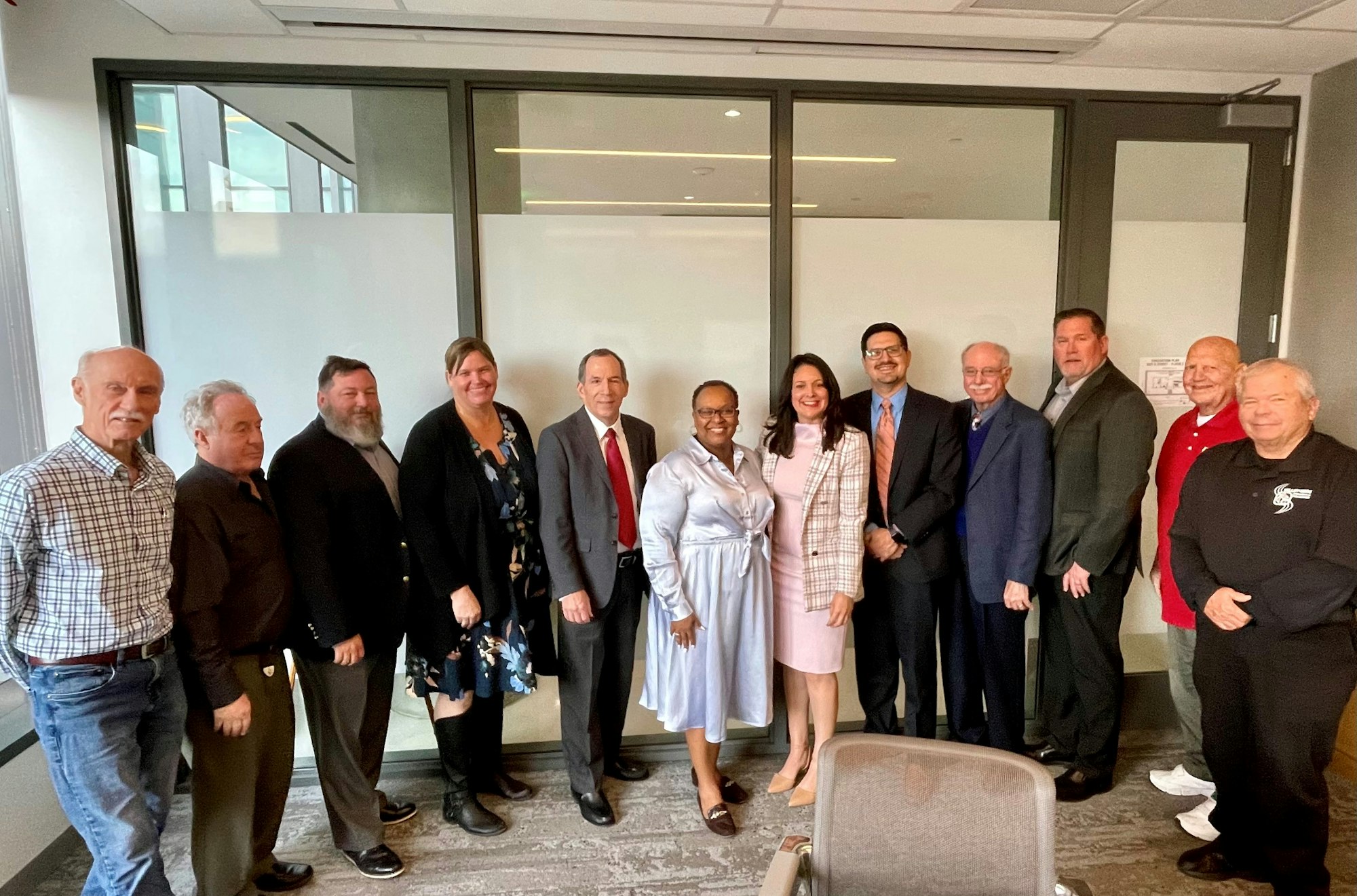 Group of people posing for a photo in an office-like setting.