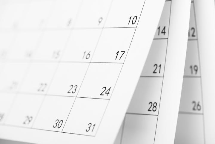 Close-up of a calendar with visible dates and overlapping pages, showing numbers like 17, 24, 31.